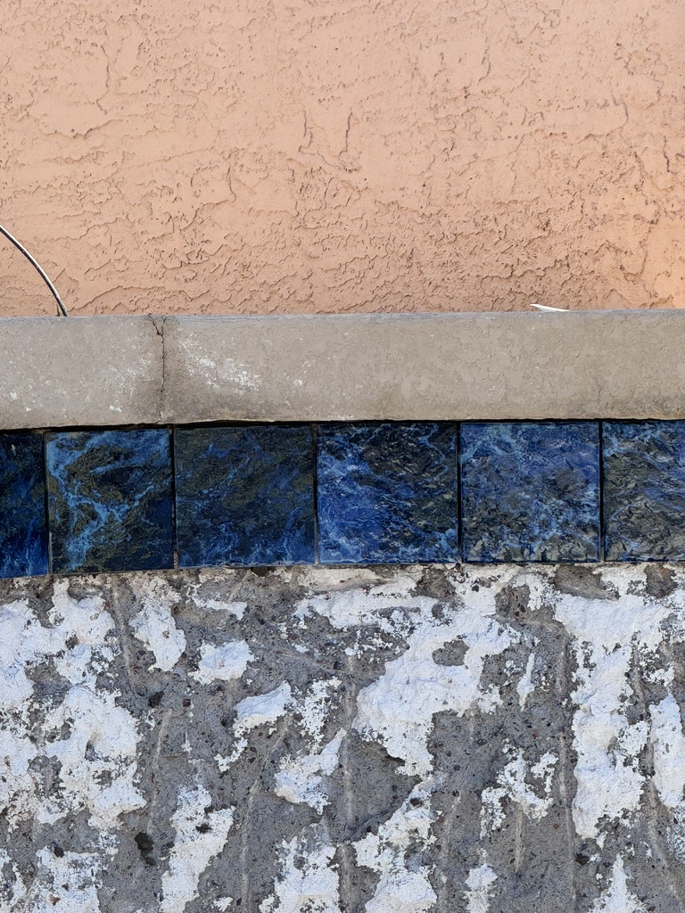 Exposed pool wall and blue waterline tile.